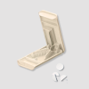 Beige pillensnijder open met witte pillen en halfjes