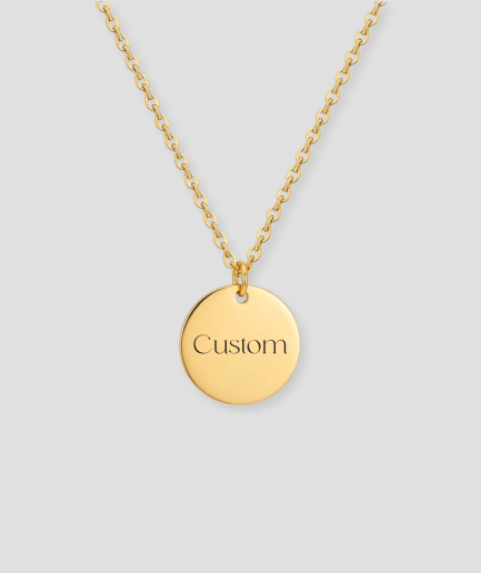 Gouden ronde schijfvormige hanger met custom tekst gravure voorbeeld aan gouden schakelketting gepersonaliseerd gouden sieraad met eigen tekst of naam gravure