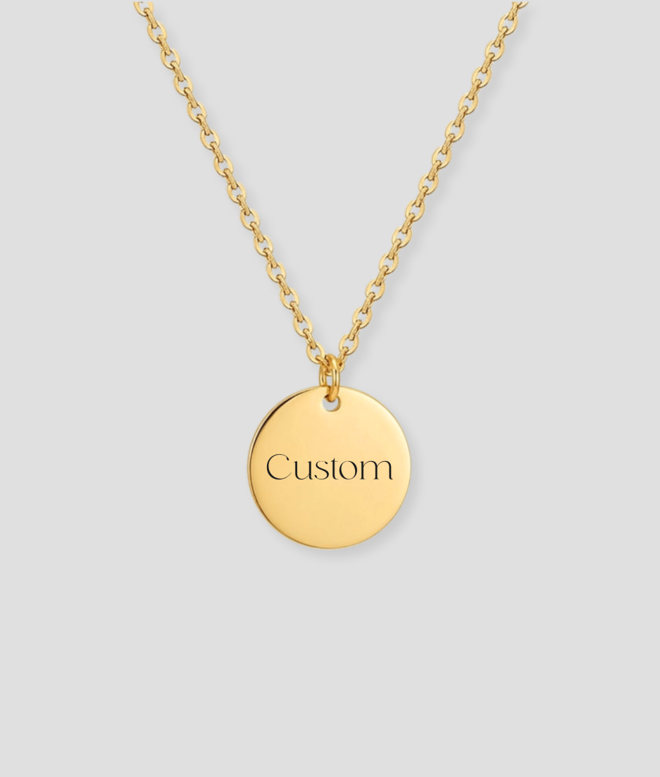 Gouden ronde schijfvormige hanger met custom tekst gravure voorbeeld aan gouden schakelketting gepersonaliseerd gouden sieraad met eigen tekst of naam gravure