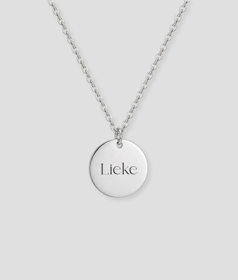 Zilveren ronde schijfvormige hanger aan zilveren schakelketting met naam gravure voorbeeld gepersonaliseerd zilveren sieraad met eigen naam of tekst