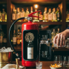 Rode brandblusser voor een bar met drankflessen op de achtergrond