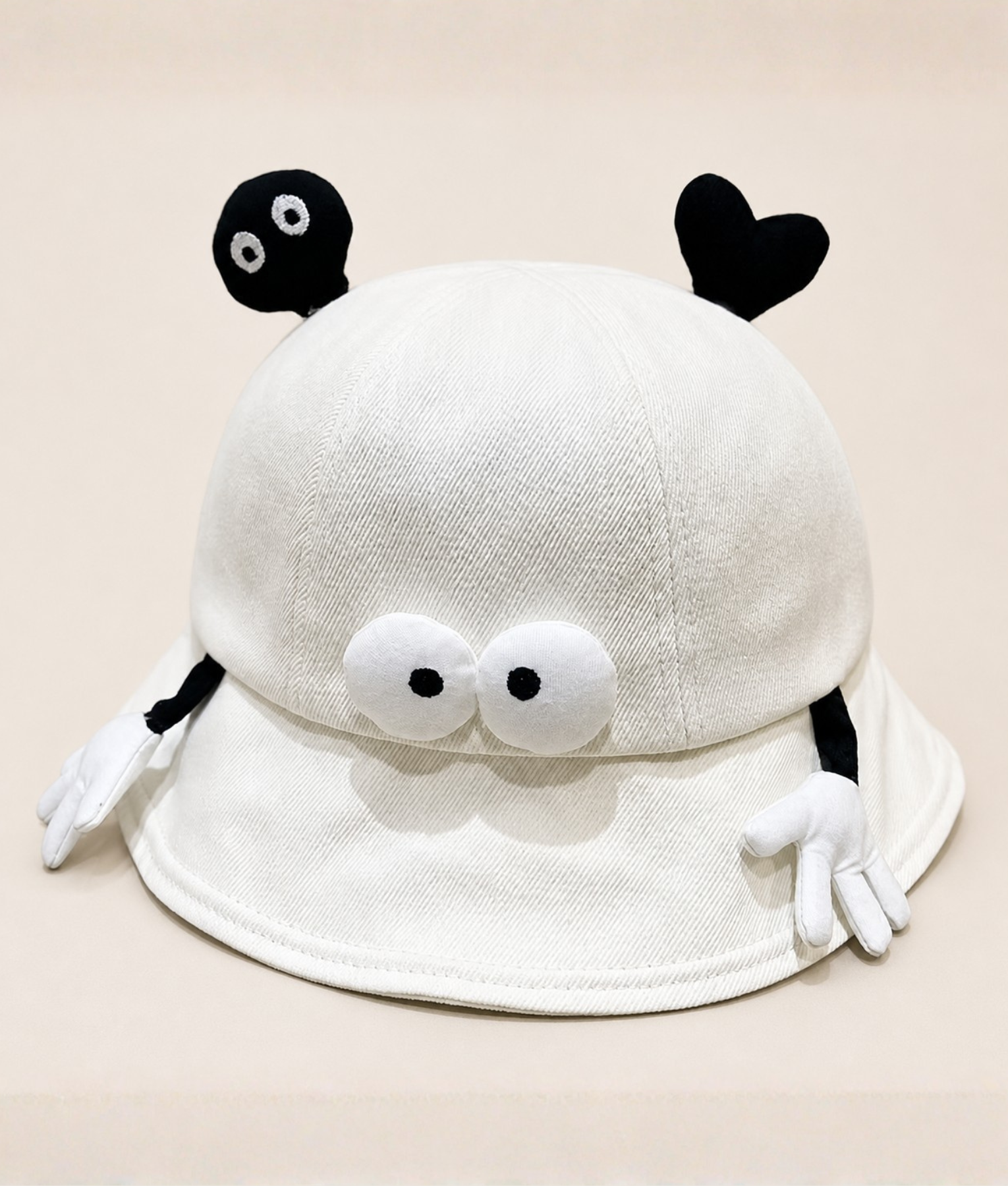 PEP SCHEP witte bucket hat met speelse decoratieve flapjes – crème denim-look vissershoed met zwarte oogjes, hartjes en kleine handjes als details