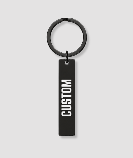 Smalle zwarte rechthoekige sleutelhanger met witte tekst CUSTOM