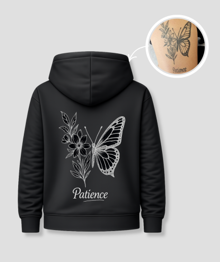 Zwarte unisex hoodie met 'Patience' vlinder en bloemen tattoo opdruk van PEP SCHEP – grote witte rugprint met botanische vlinder illustratie