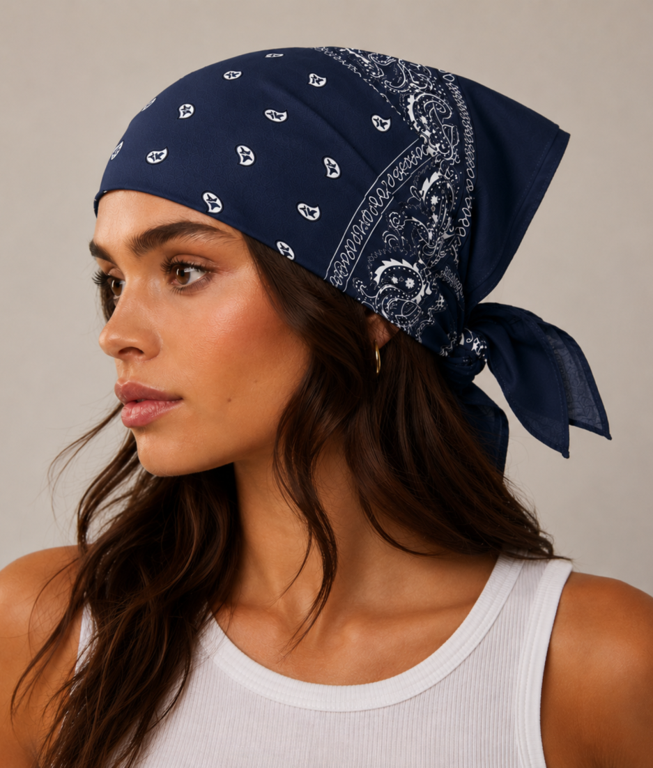 Donkerblauwe bandana gedragen door model – klassieke paisley bandana in donkerblauw met witte print, gedragen als hoofddoek. Veelzijdig te stylen als haarband, nekdoek of accessoire. Ideaal als cadeau of festival- en zomeraccessoire.