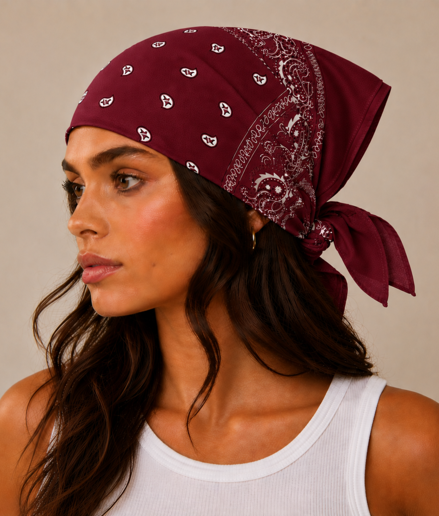 Donkerrode bandana gedragen door model – klassieke paisley bandana in donkerrood met witte print, gedragen als hoofddoek. Veelzijdig te stylen als haarband, nekdoek of accessoire. Ideaal als cadeau of festival- en zomeraccessoire.