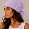 Lila lichtpaarse bandana gedragen door model – klassieke paisley bandana in lila lichtpaars met witte print, gedragen als hoofddoek. Veelzijdig te stylen als haarband, nekdoek of accessoire. Ideaal als cadeau of festival- en zomeraccessoire.