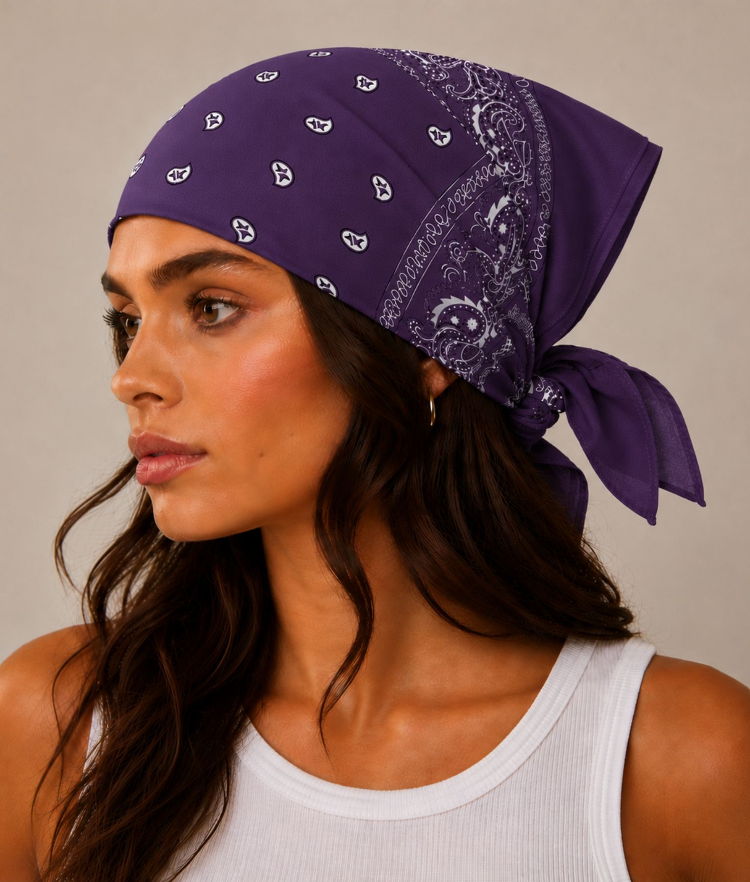 Paarse bandana gedragen door model – klassieke paisley bandana in paars met witte print, gedragen als hoofddoek. Veelzijdig te stylen als haarband, nekdoek of accessoire. Ideaal als cadeau of festival- en zomeraccessoire.
