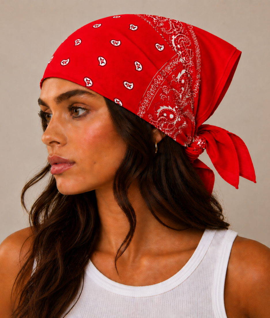 Rode bandana gedragen door model – klassieke paisley bandana in rood met witte print, gedragen als hoofddoek. Veelzijdig te stylen als haarband, nekdoek of accessoire. Ideaal als cadeau of festival- en zomeraccessoire.