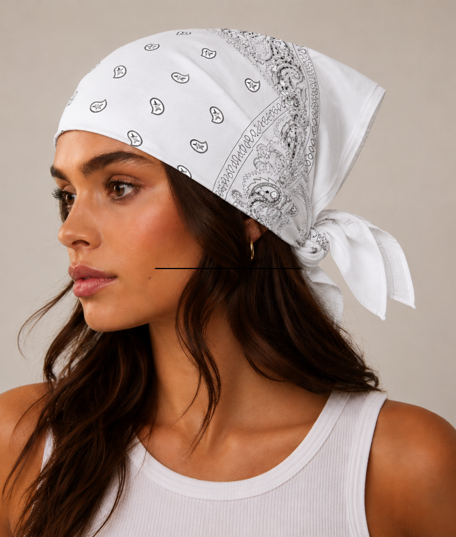 Witte bandana gedragen door model – klassieke paisley bandana in wit met grijze print, gedragen als hoofddoek. Veelzijdig te stylen als haarband, nekdoek of accessoire. Ideaal als cadeau of festival- en zomeraccessoire.