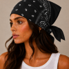 Zwarte bandana gedragen door model – klassieke paisley bandana in zwart met witte print, gedragen als hoofddoek. Veelzijdig te stylen als haarband, nekdoek of accessoire. Ideaal als cadeau of festival- en zomeraccessoire.