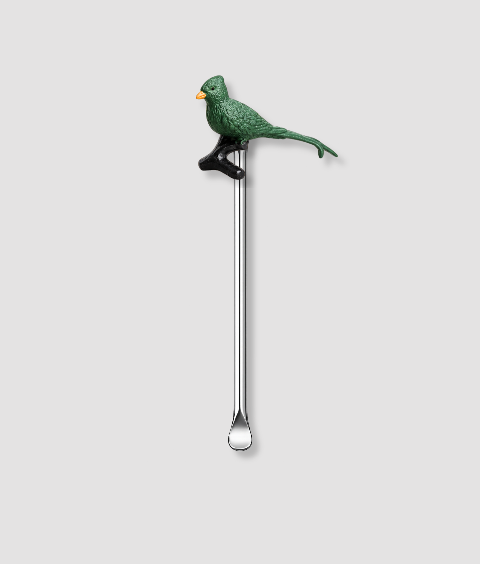 Mini schepje cocktailstirrer met groene vogel figuur zittend op een zwarte tak met gele snavel bovenop en zilveren steel