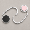 Close-up tassenhanger geopend en ingeklapt zilver roze zwart