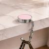 Roze opvouwbare tassenhanger close-up aan tafel