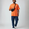 Zwarte fannypack heuptasje gedragen over een oranje T-shirt