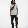 Man met zwarte crossbody fanny pack over grijs T-shirt