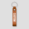 Cognackleurige leren sleutelhanger met zilveren ring, voorbeeldtekst 'CUSTOM'
