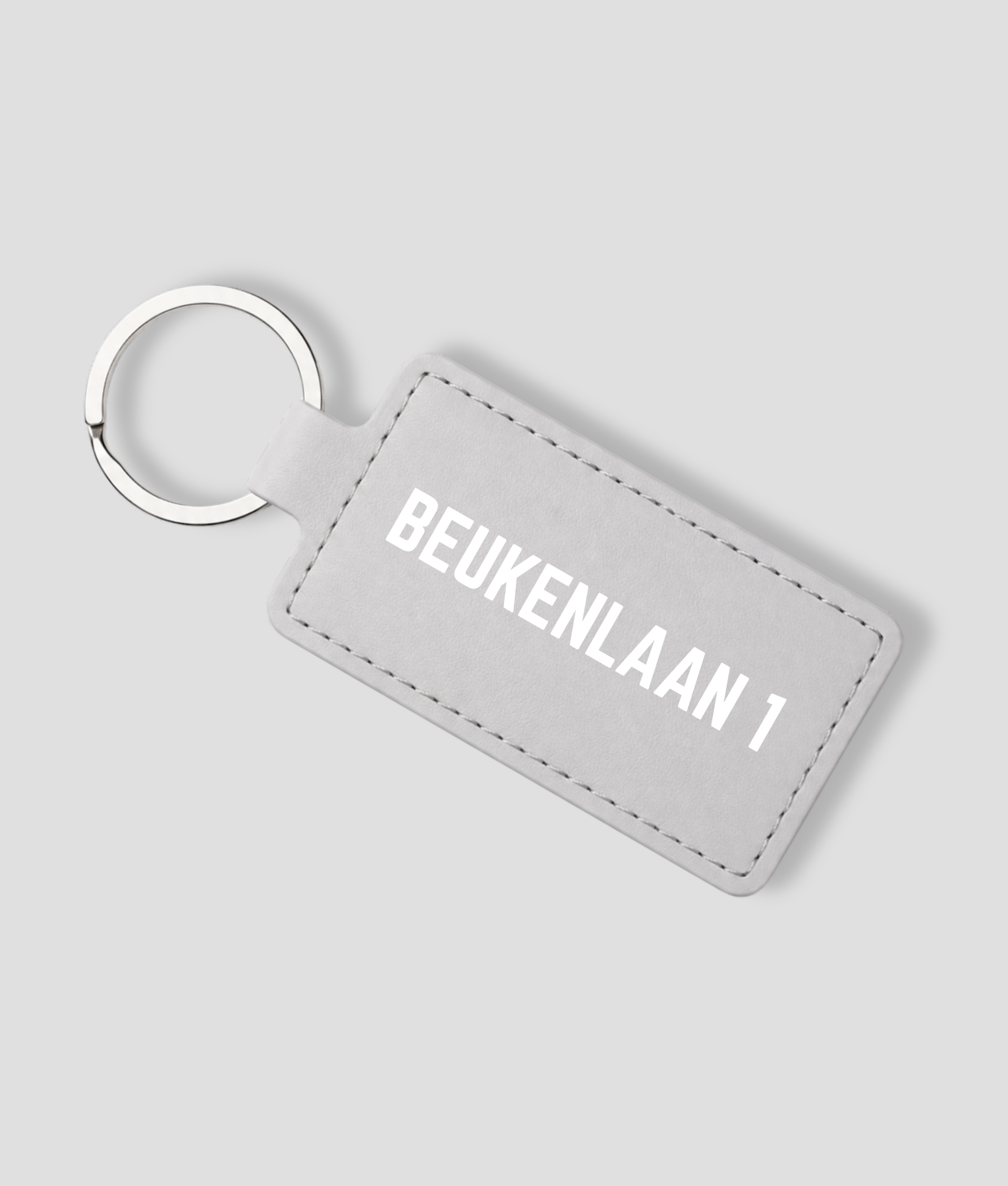 Lichtgrijze leren sleutelhanger die je zelf kunt personaliseren met eigen tekst