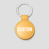 Gouden ronde leren sleutelhanger, voorbeeldtekst 'CUSTOM'