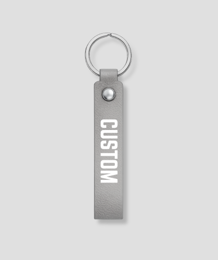 Grijze leren sleutelhanger met zilveren ring, voorbeeldtekst 'CUSTOM'