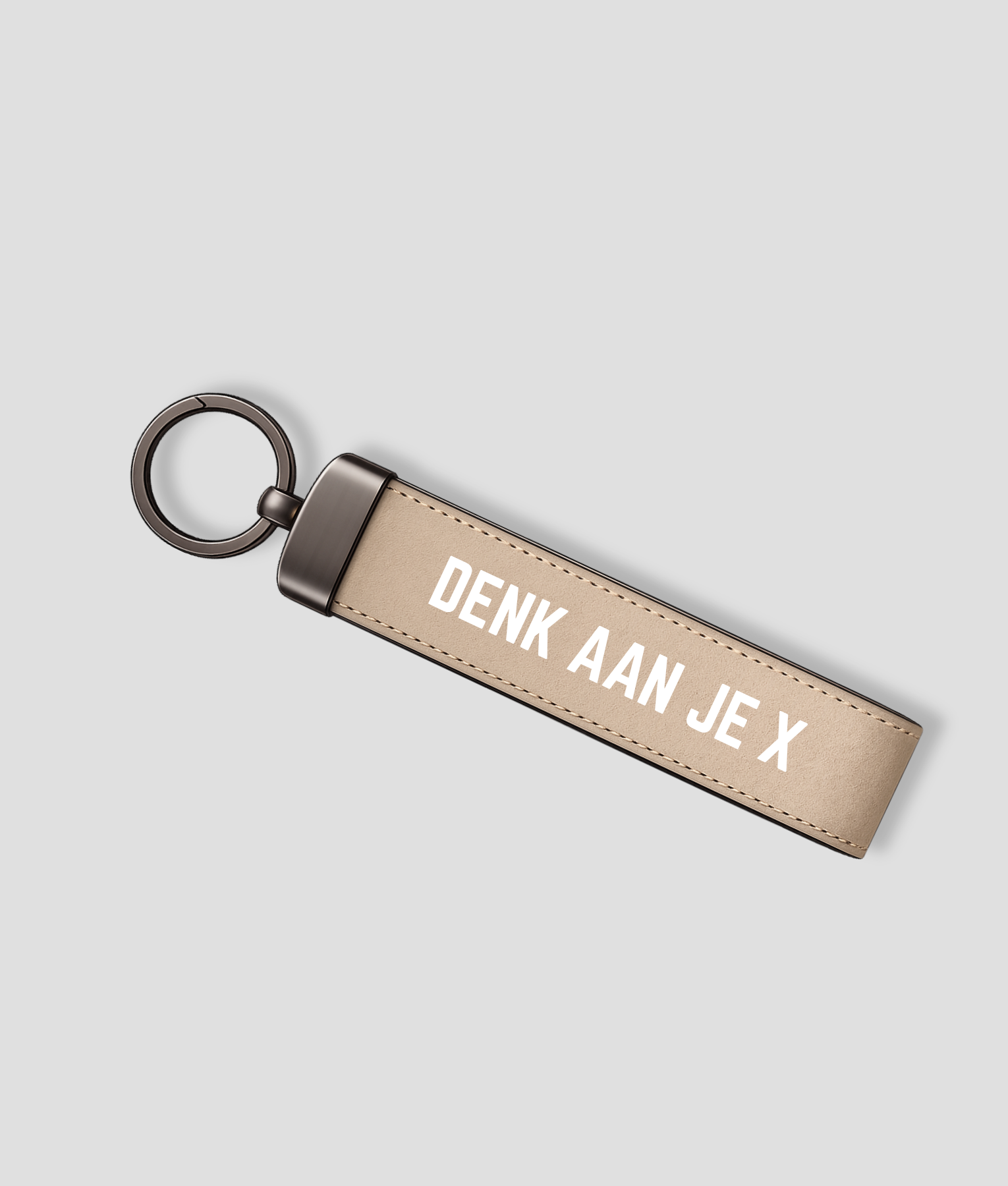 Zandkleurige suède sleutelhanger met metalen ring en tekst 'DENK AAN JE X'