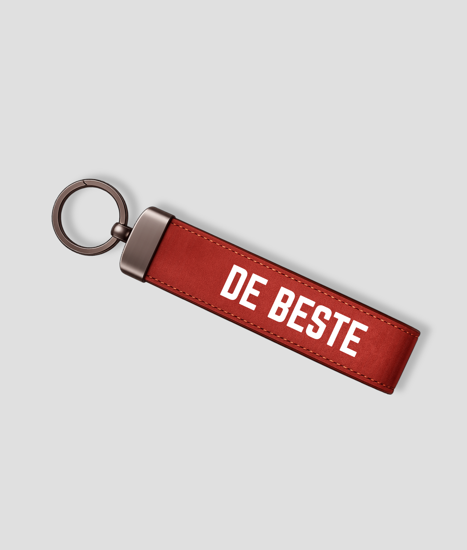 Roodbruine suède sleutelhanger met metalen ring en tekst 'DE BESTE'