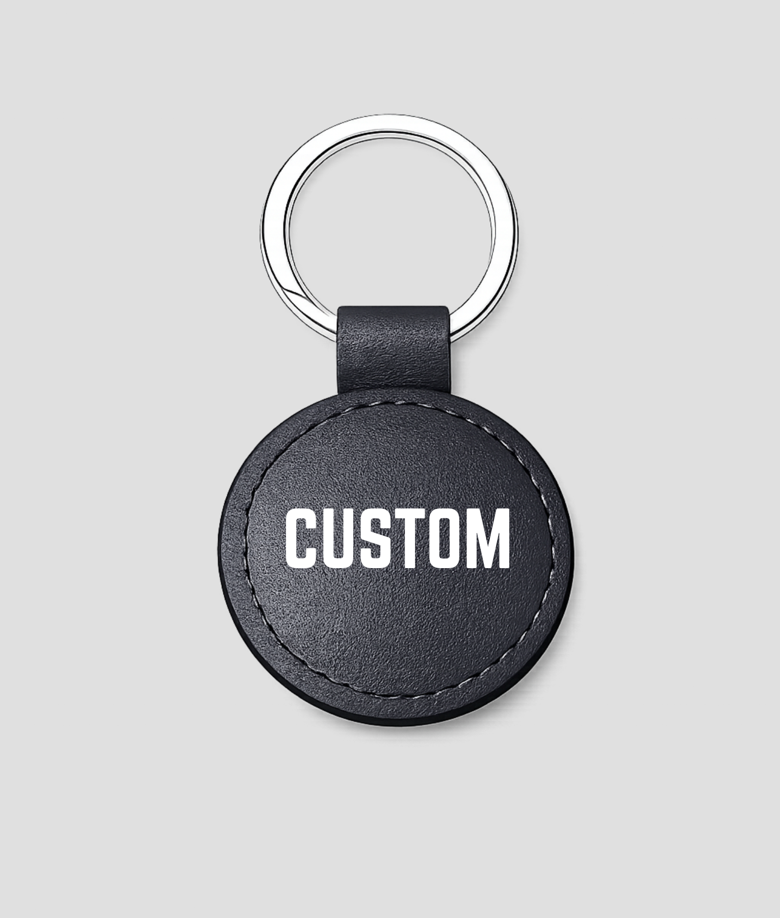 Zwarte ronde leren sleutelhanger met zilveren ring, voorbeeldtekst 'CUSTOM'