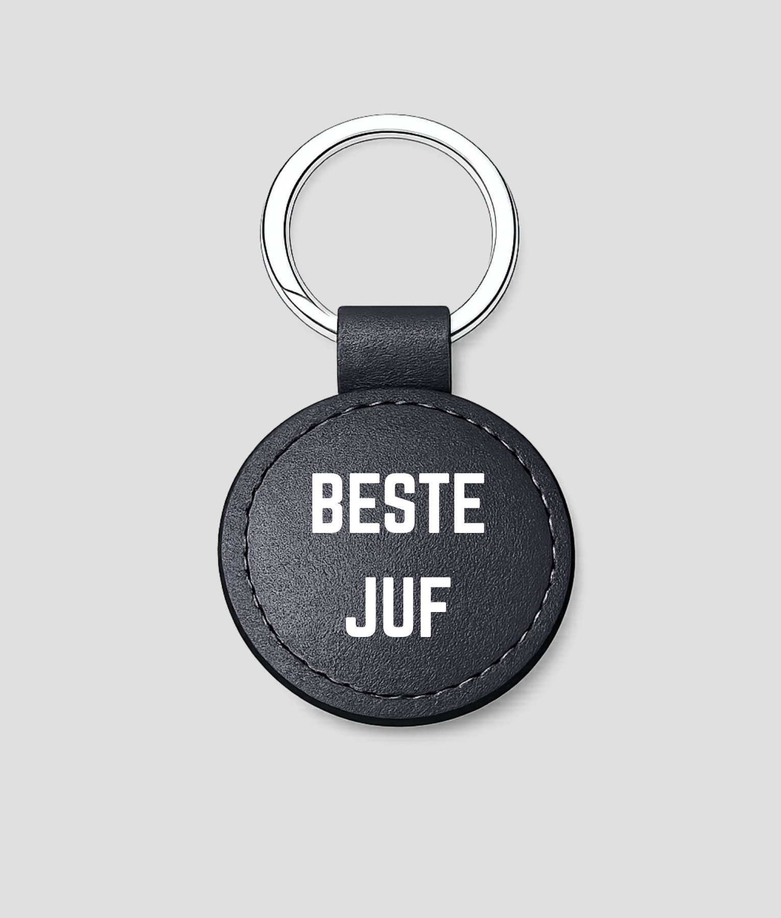 Zwarte ronde leren sleutelhanger met zilveren ring en tekst 'BESTE JUF'